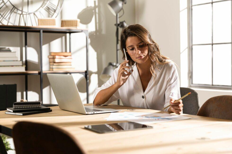 mid-shot-woman-talking-phone-table (1)